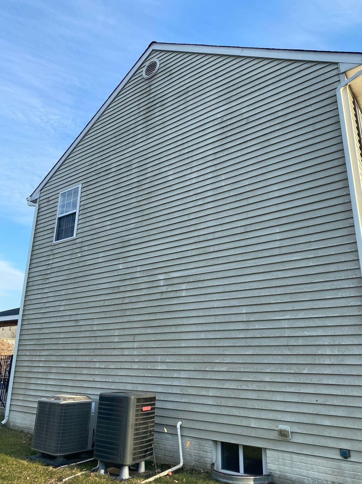 Side wall of a grey-sided house before cleaning