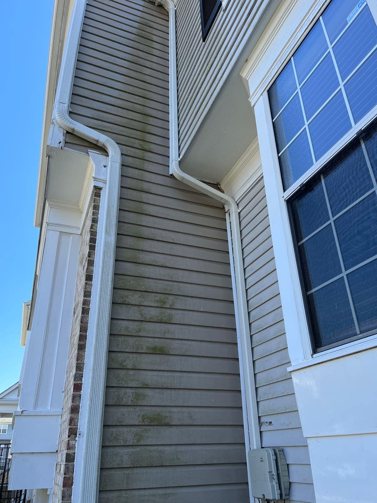 Corner siding and window before a house wash