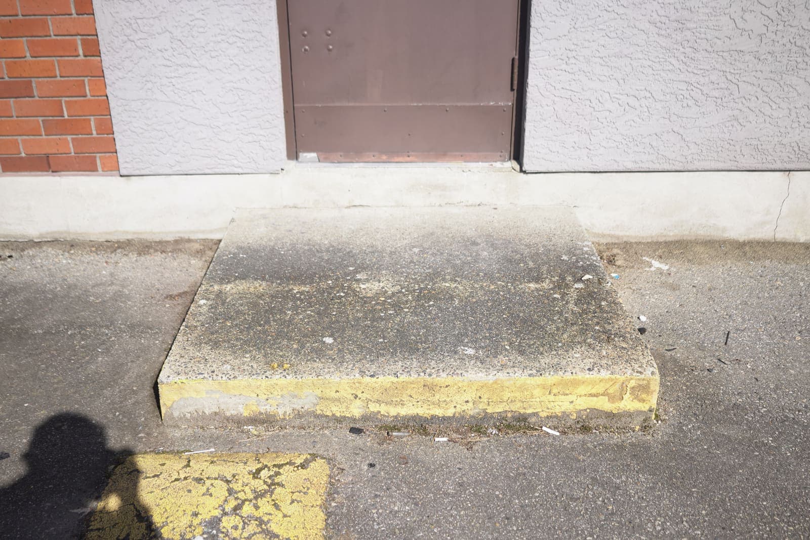 Stained concrete step at a commercial unit before pressure washing