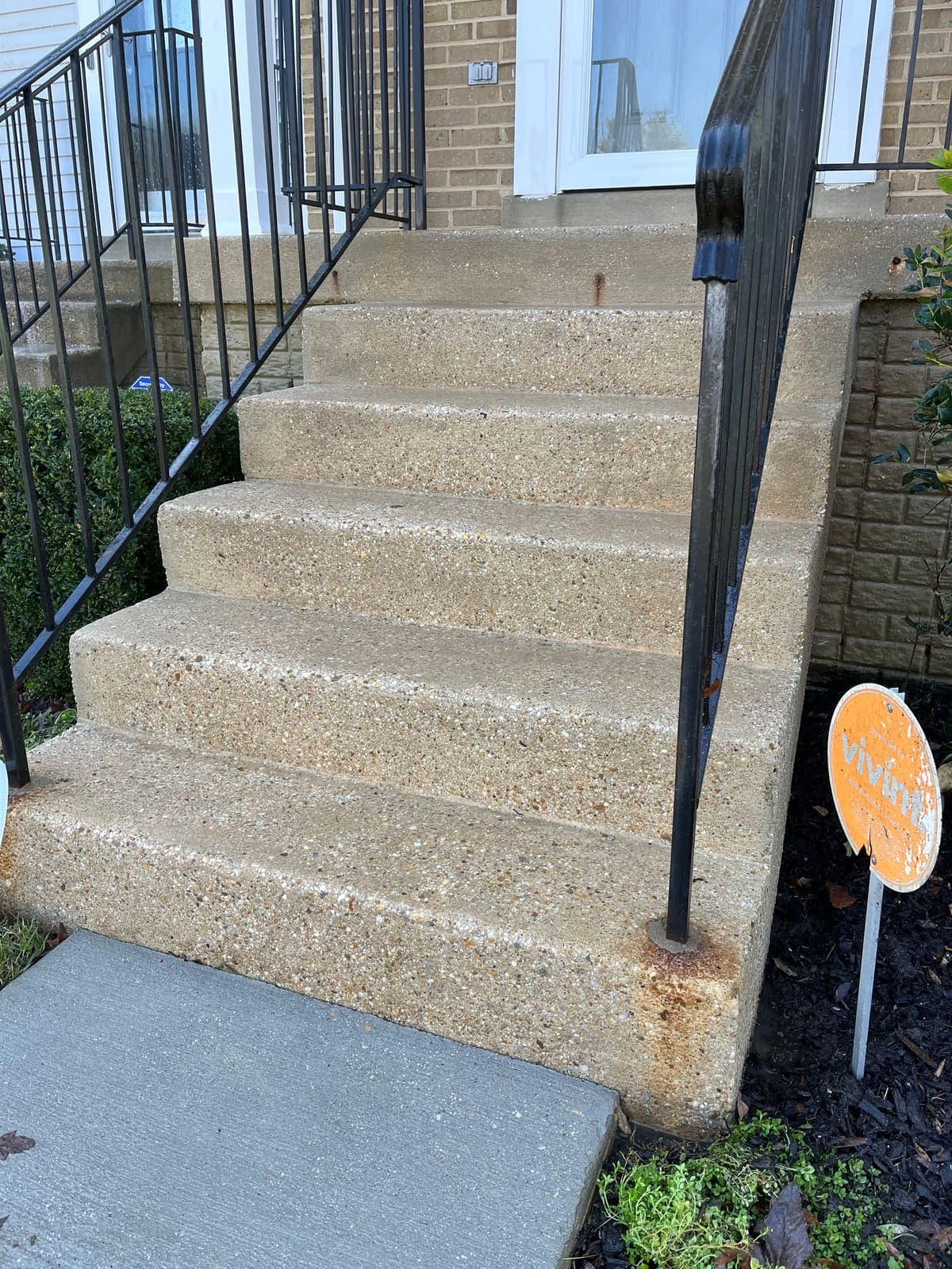 Stained concrete steps and handrail before washing