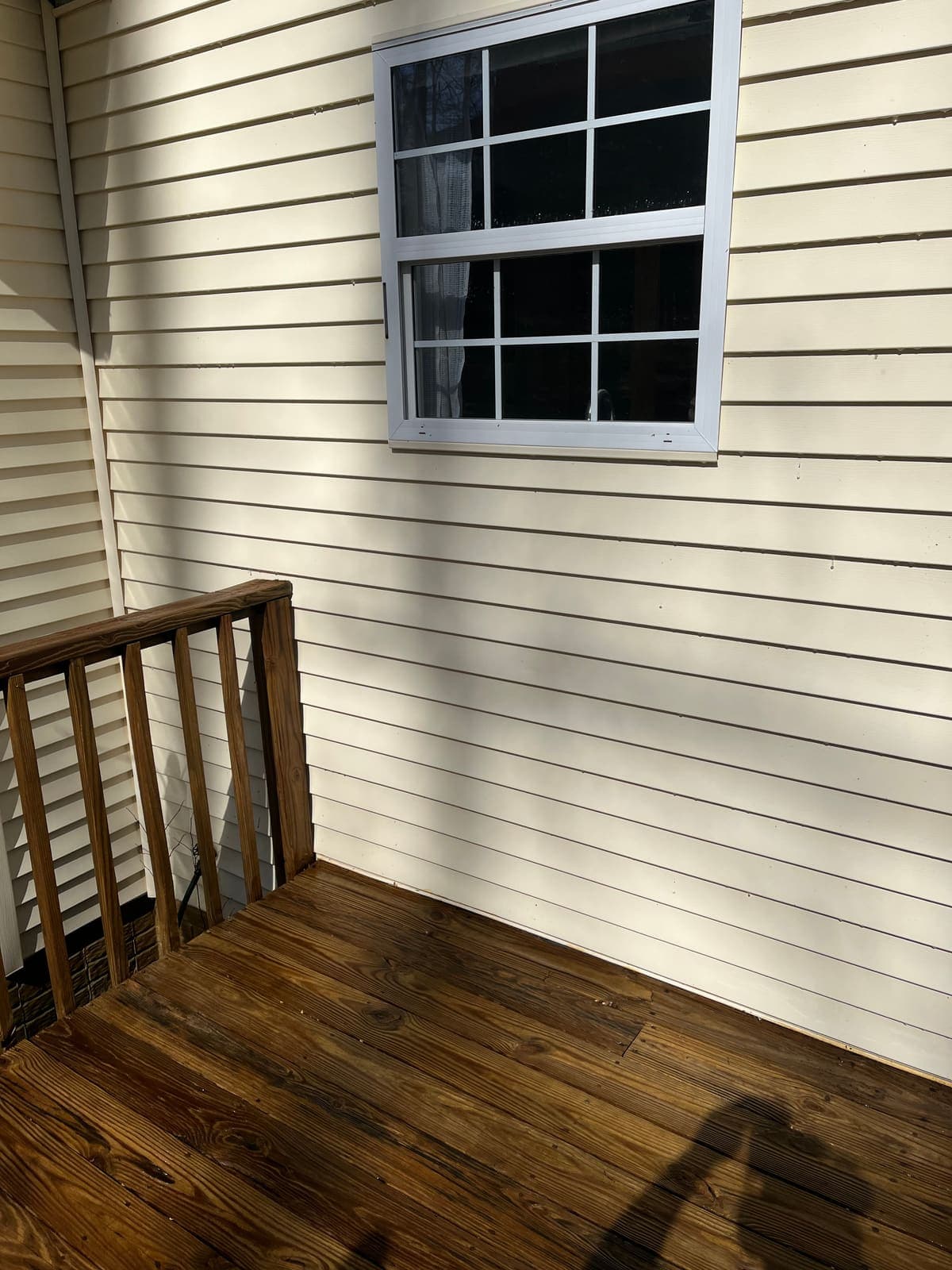 Restored deck boards next to freshly cleaned siding