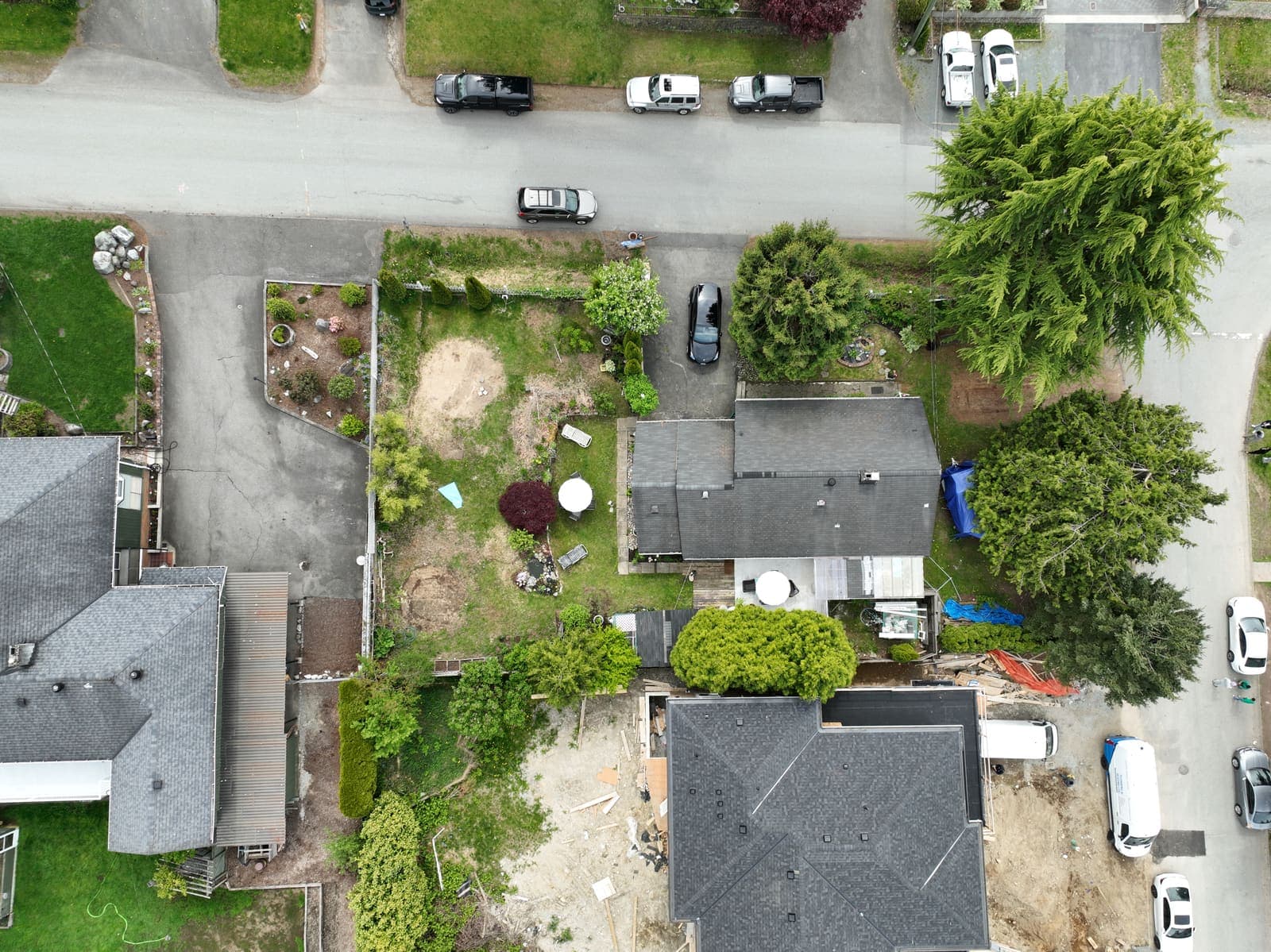 Drone view over residential rooftops and driveways on a quiet street