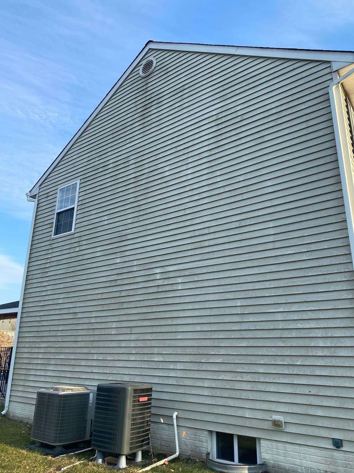 Side wall of a grey-sided house before cleaning