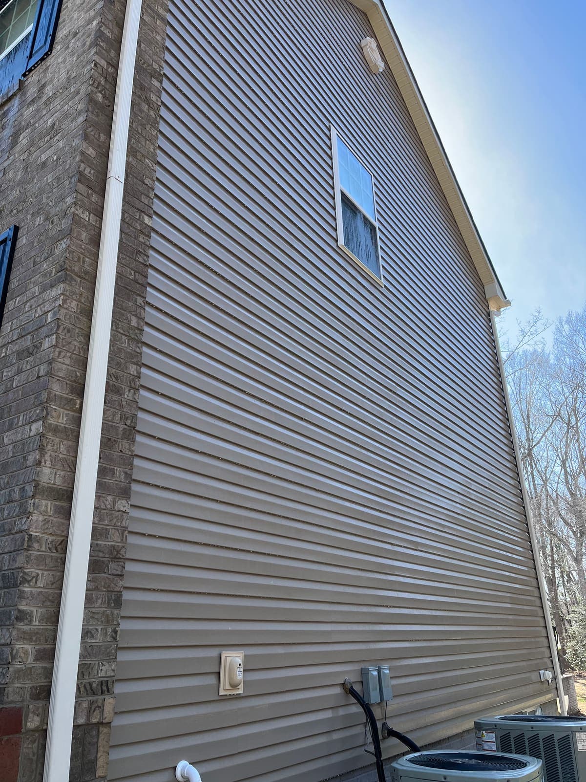 Siding beside an air conditioning unit before cleaning