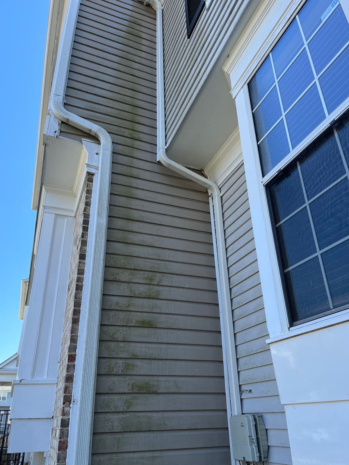 Corner siding and window before a house wash