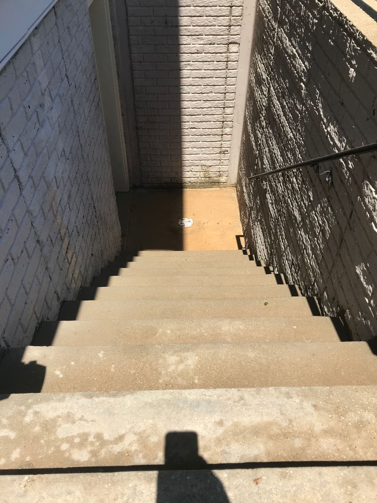 Concrete stairwell half cleaned, showing the difference