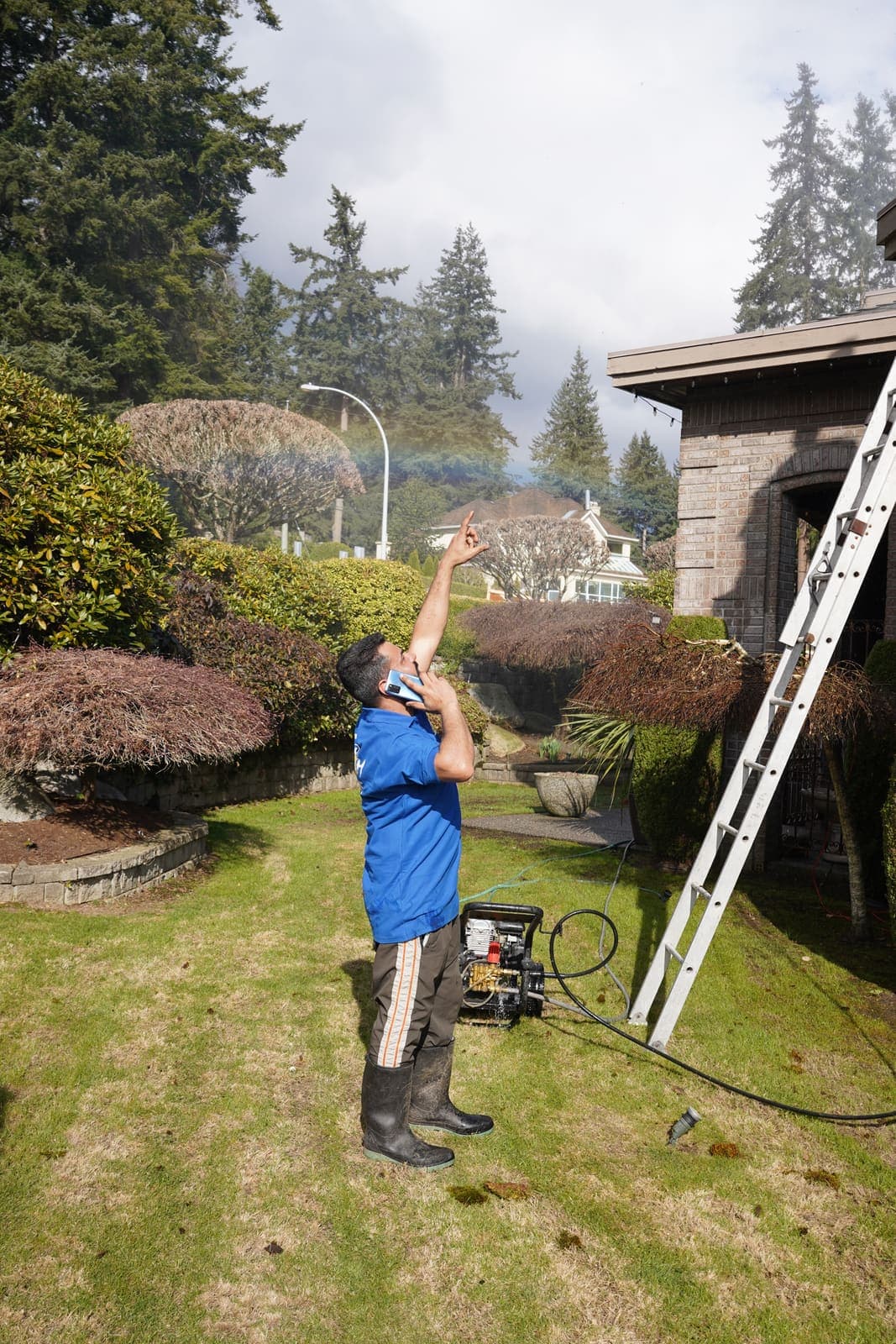 Technician setting up an extension ladder on the lawn before starting work