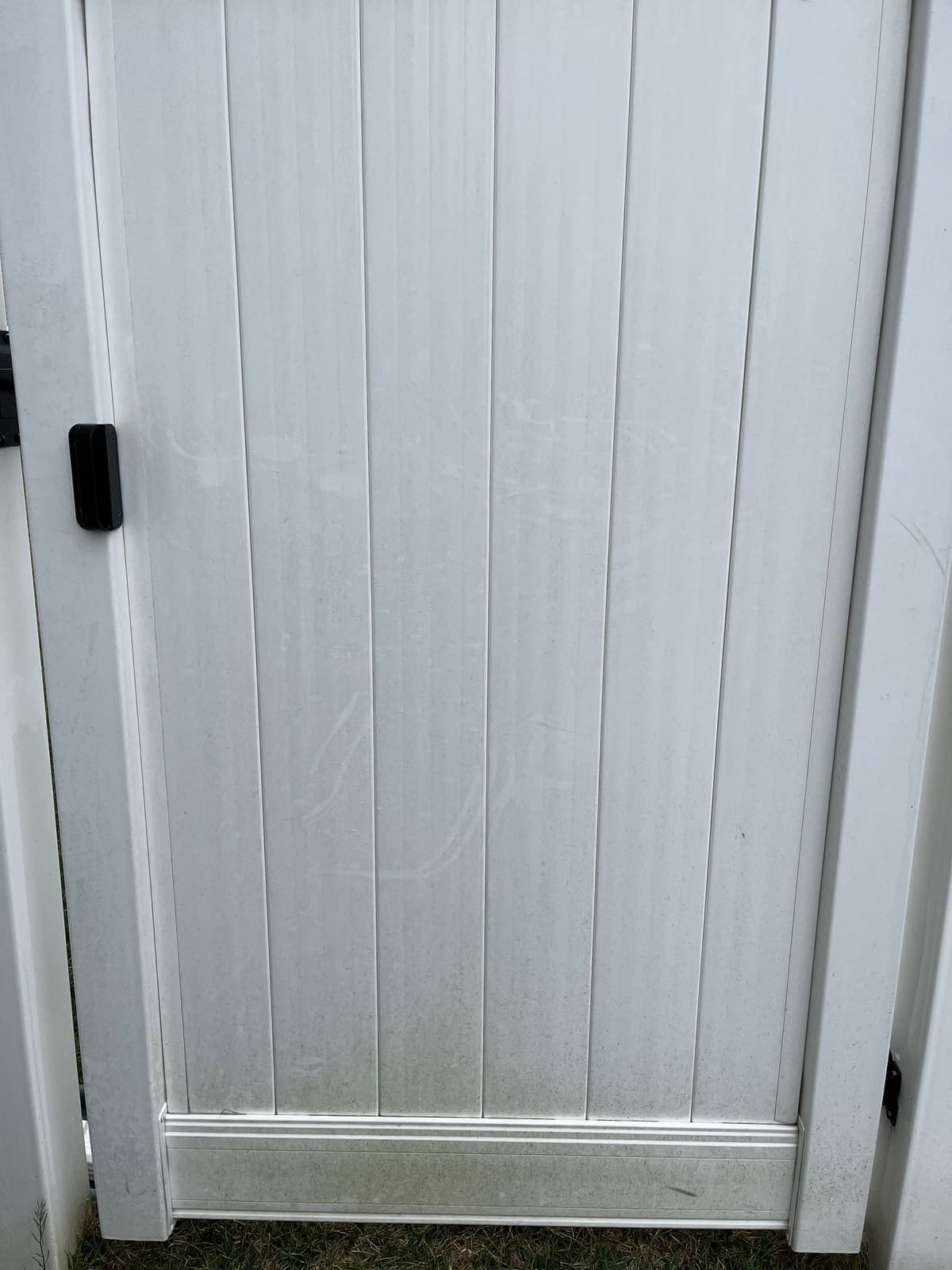 White vinyl fence gate after pressure washing