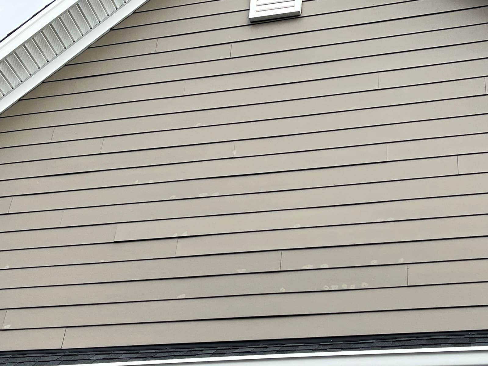 Wide siding panel showing dirt build-up before washing