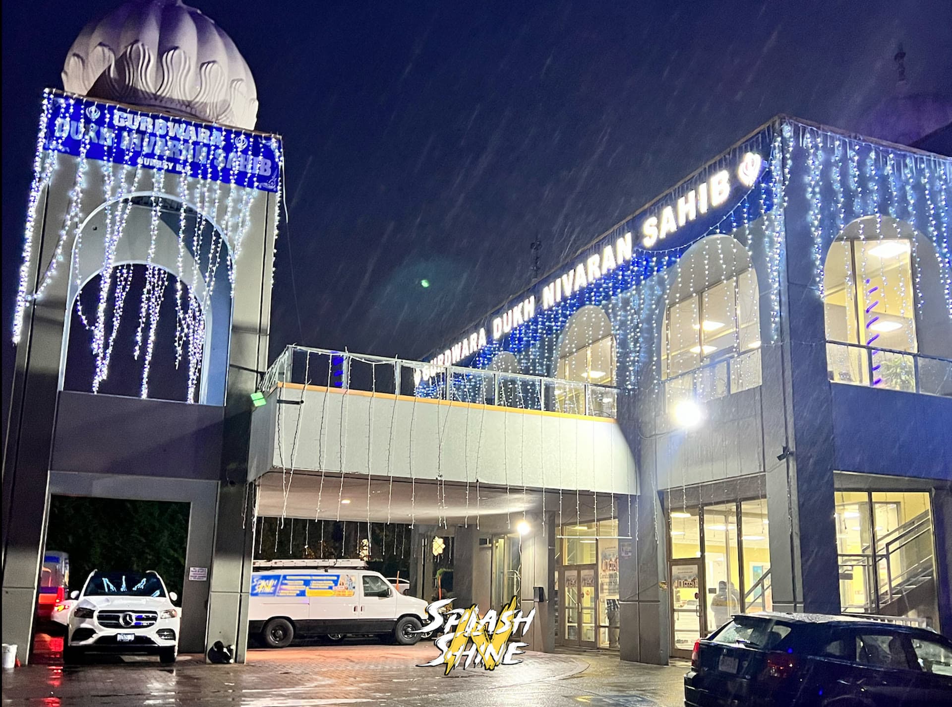 Gurdwara Dukh Nivaran Sahib in Surrey decorated with cascading white festival lights at night