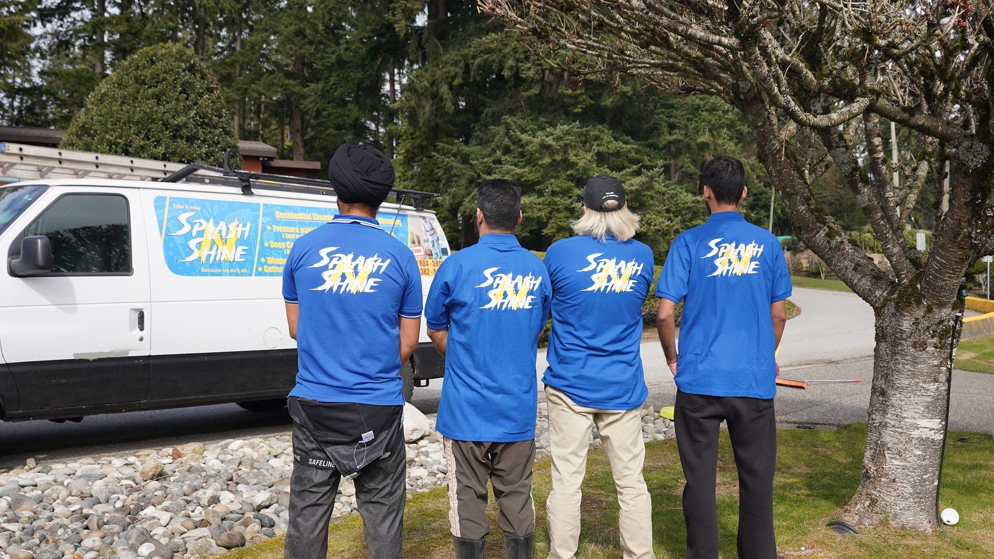 The Splash N Shine crew in branded uniforms standing at their service van before starting a job in the Lower Mainland